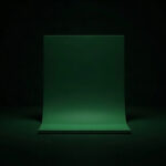 A plain green document shape glowing on a black background
