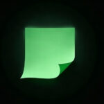 A single blank green sheet of paper with a curled corner