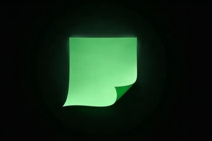 A single blank green sheet of paper with a curled corner